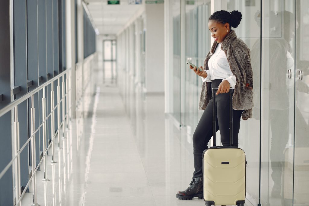 black woman with suitcase at the airport